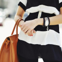 Fashionable woman holding a handbag in hands - close up
