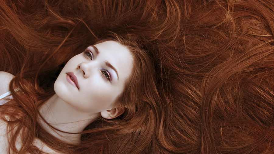 portrait of a girl with beautiful long red shiny hair