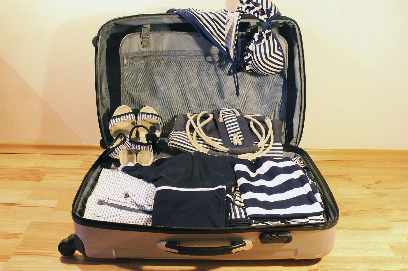 Suitcase with striped clothes and accessories in a marine style