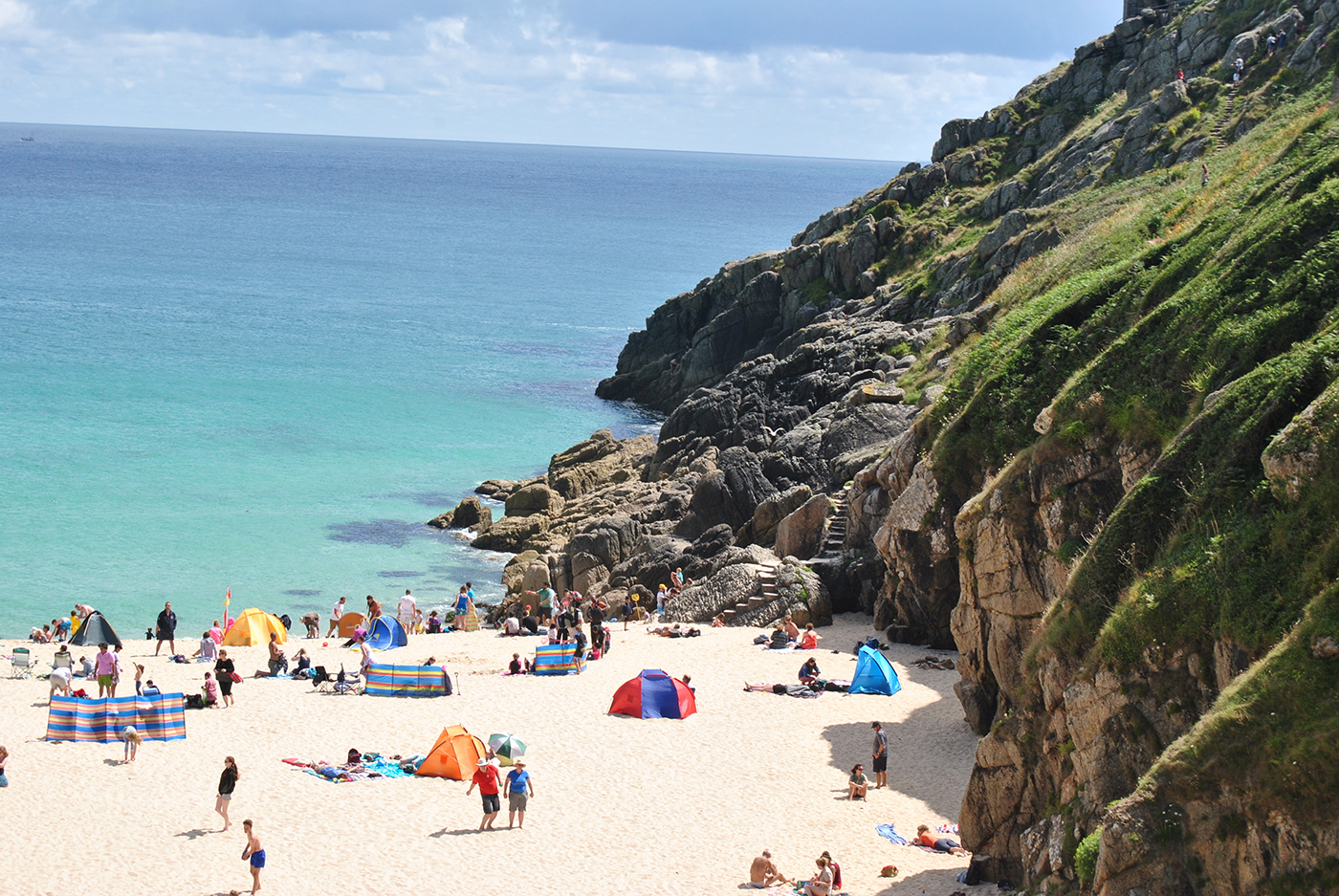 CORNWALL, ENGLAND: Busy Porthcurno Beach in the lovely summer day, minutes walk from Minack Theater