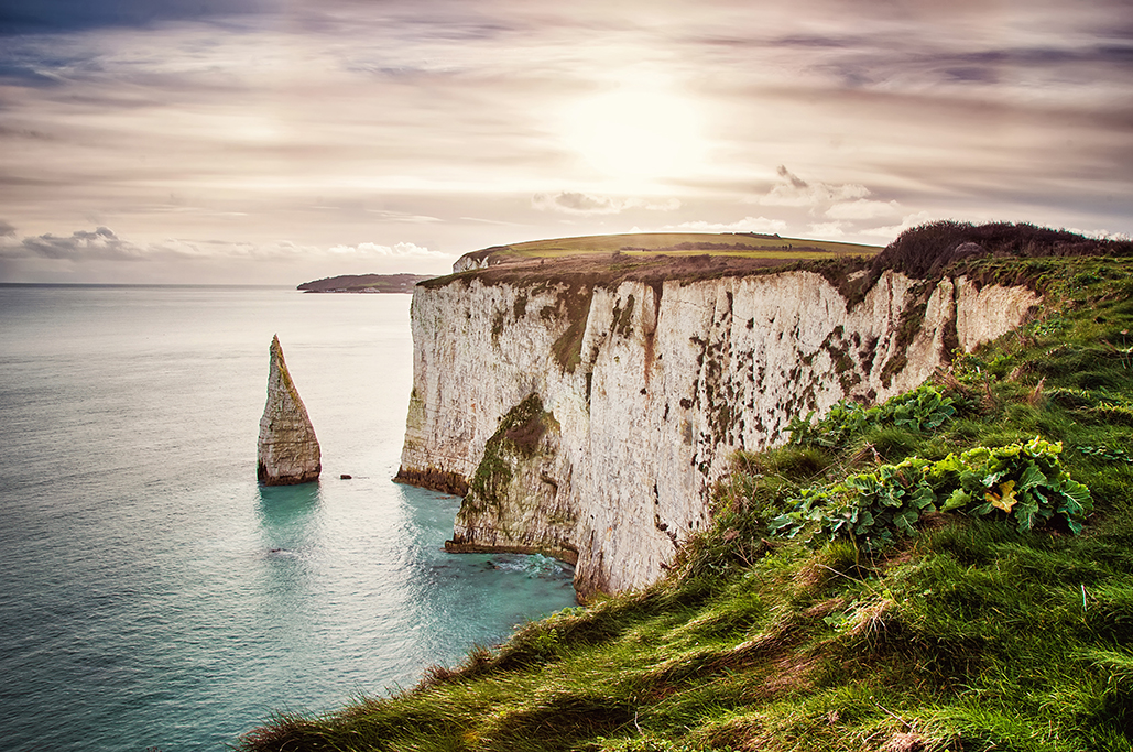 Old Harry Rocks, located at Handfast Point, on the Isle of Purbeck in Dorset, southern England, United Kingdom; the downlands of Ballard Down were formed approximately 66 million years ago