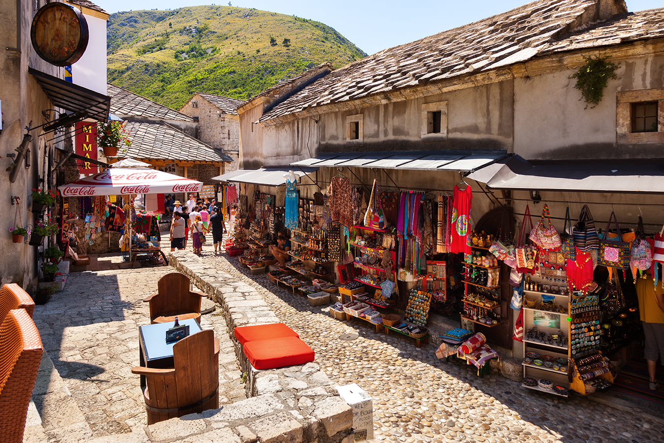 People walking through the Old Town with many shops and cafes on July 20, 2014 in Mostar, Bosnia and Herzegovina. Mostar is situated on the Neretva River.