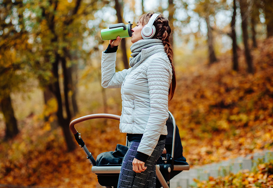 sporty woman drinking coffee in fall